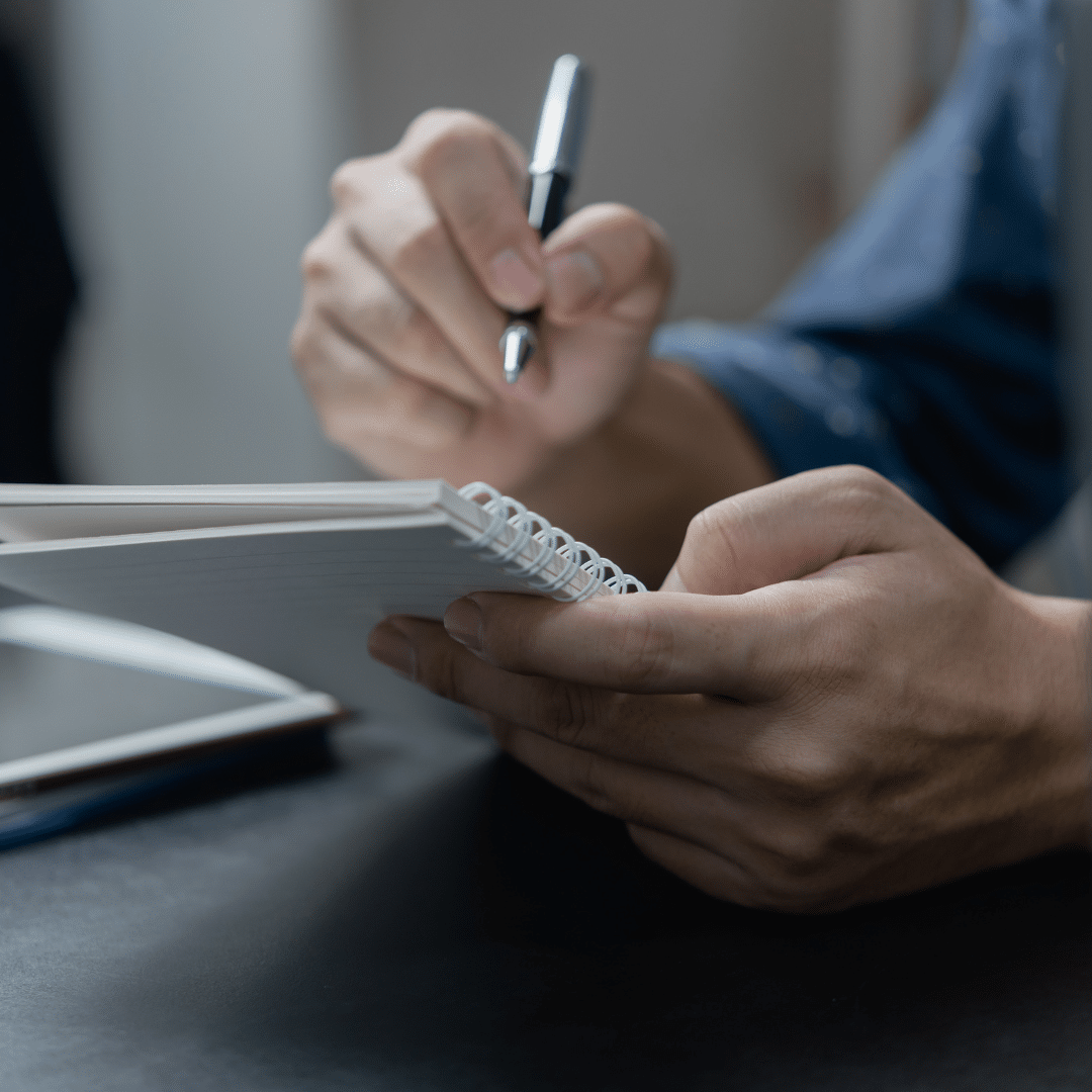 Student taking handwritten notes whilst working with a tutor online
